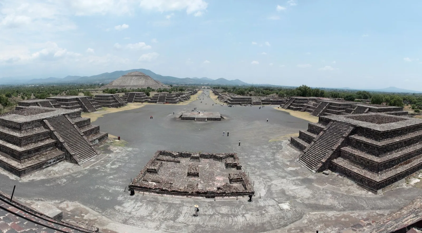 View from the Pyramid of the Moon down the Avenue of the Dead, with stepped platforms in the foreground and the Pyramid of the Sun in the distance