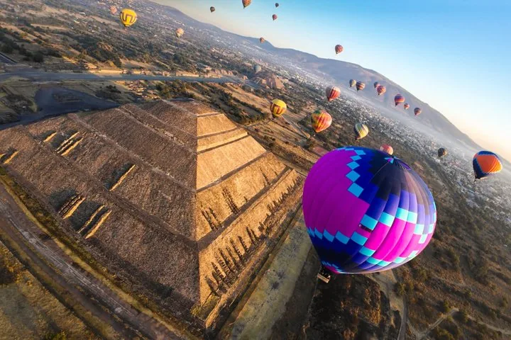 Aerial view of a purple balloon beside the Pyramid of the Sun at sunrise